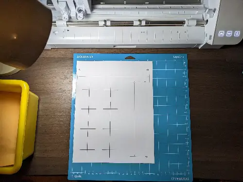 demonstrating how to place the cameo 4 calibration page onto a cutting mat